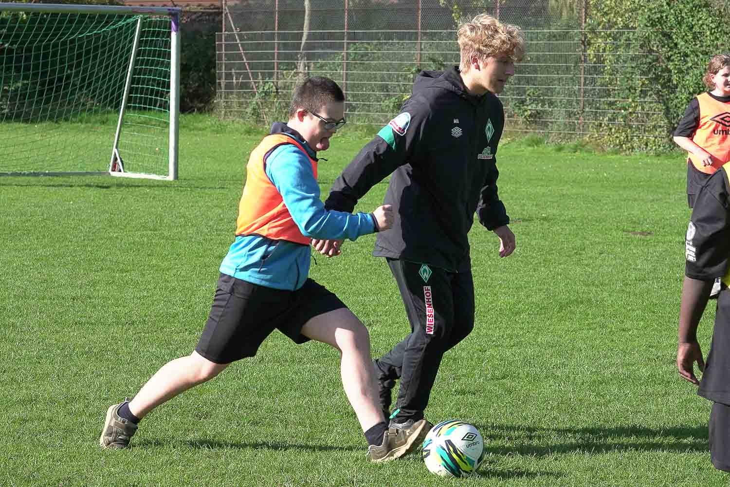 Hand in Hand: Ein junger Kicker zusammen mit einem SVW-Trainer. (Foto: David Dischinger)
